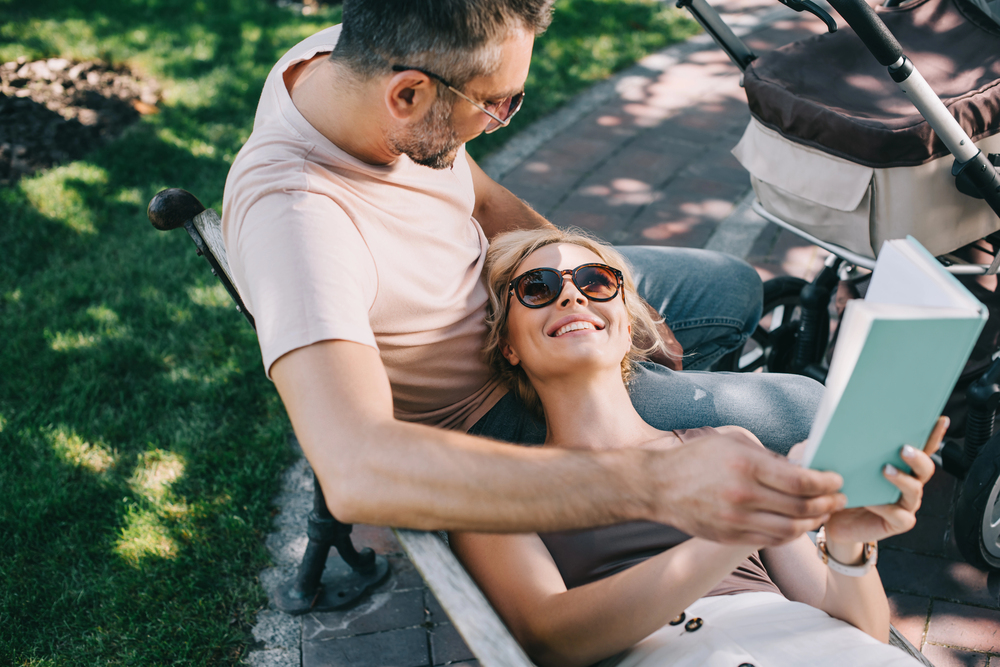 High angle view of smiling wife lying on husband legs